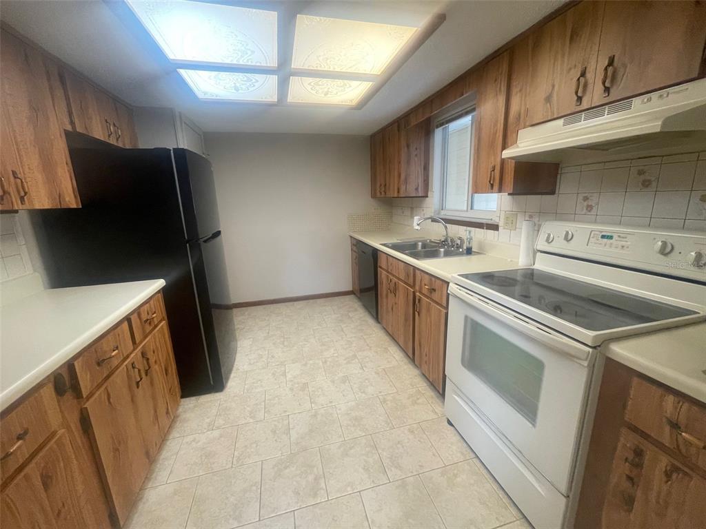 10028 Southwest 88th Terrace Ocala, FL 34481 - Photo 2 of 22 a kitchen with stainless steel appliances granite countertop a sink stove and refrigerator