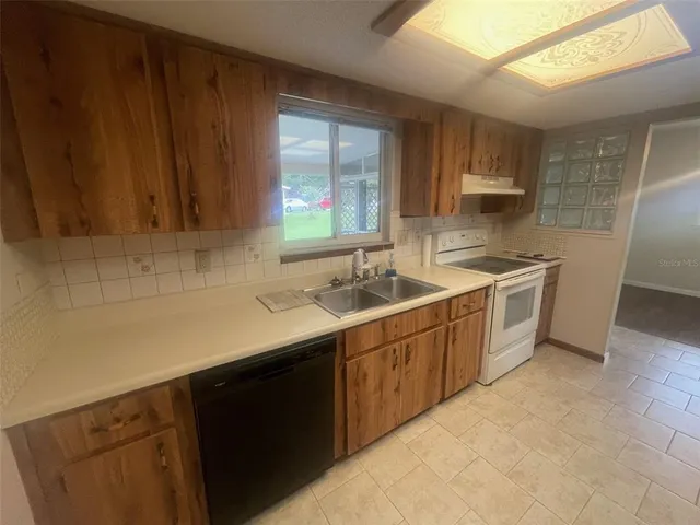 a kitchen with a sink dishwasher a stove and a refrigerator
