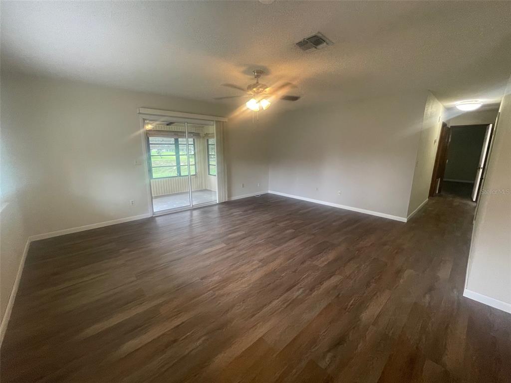 10028 Southwest 88th Terrace Ocala, FL 34481 - Photo 5 of 22 an empty room with wooden floor and windows