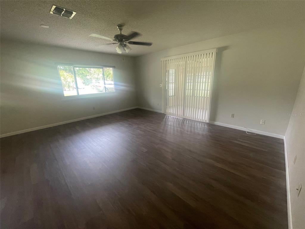 10028 Southwest 88th Terrace Ocala, FL 34481 - Photo 6 of 22 an empty room with wooden floor and windows
