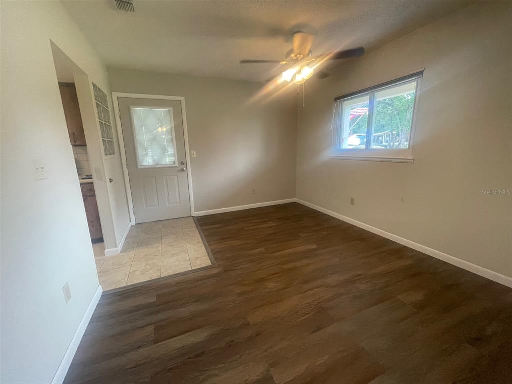 10028 Southwest 88th Terrace Ocala, FL 34481 - Photo 7 of 22 an empty room with wooden floor mirror and windows