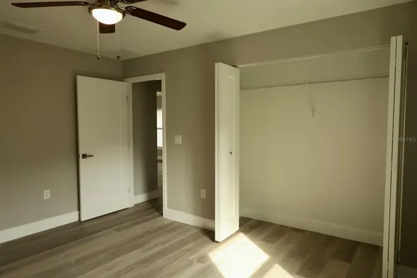 an empty room with wooden floor and a window