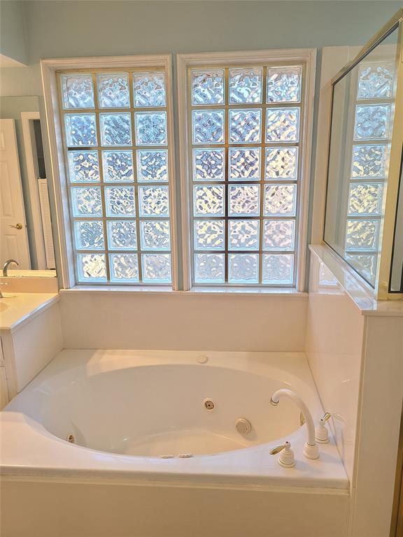 8921 Bontura Road Granbury, TX 76049 - Photo 20 of 26 a bathroom with a bathtub and a window