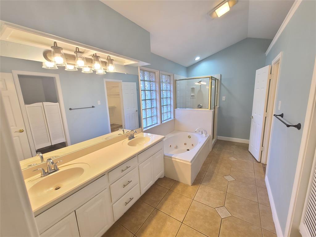 8921 Bontura Road Granbury, TX 76049 - Photo 22 of 26 a spacious bathroom with a double vanity sink and a mirror