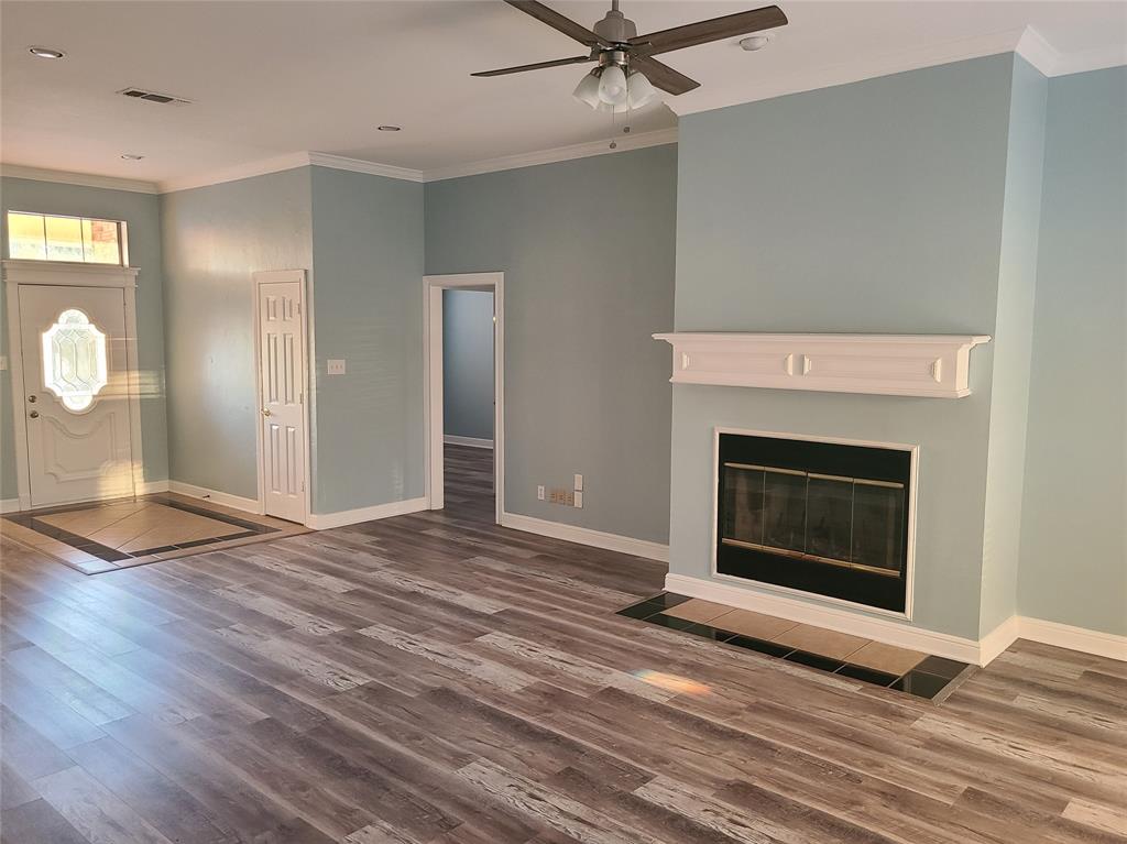 8921 Bontura Road Granbury, TX 76049 - Photo 3 of 26 an empty room with wooden floor a fireplace
