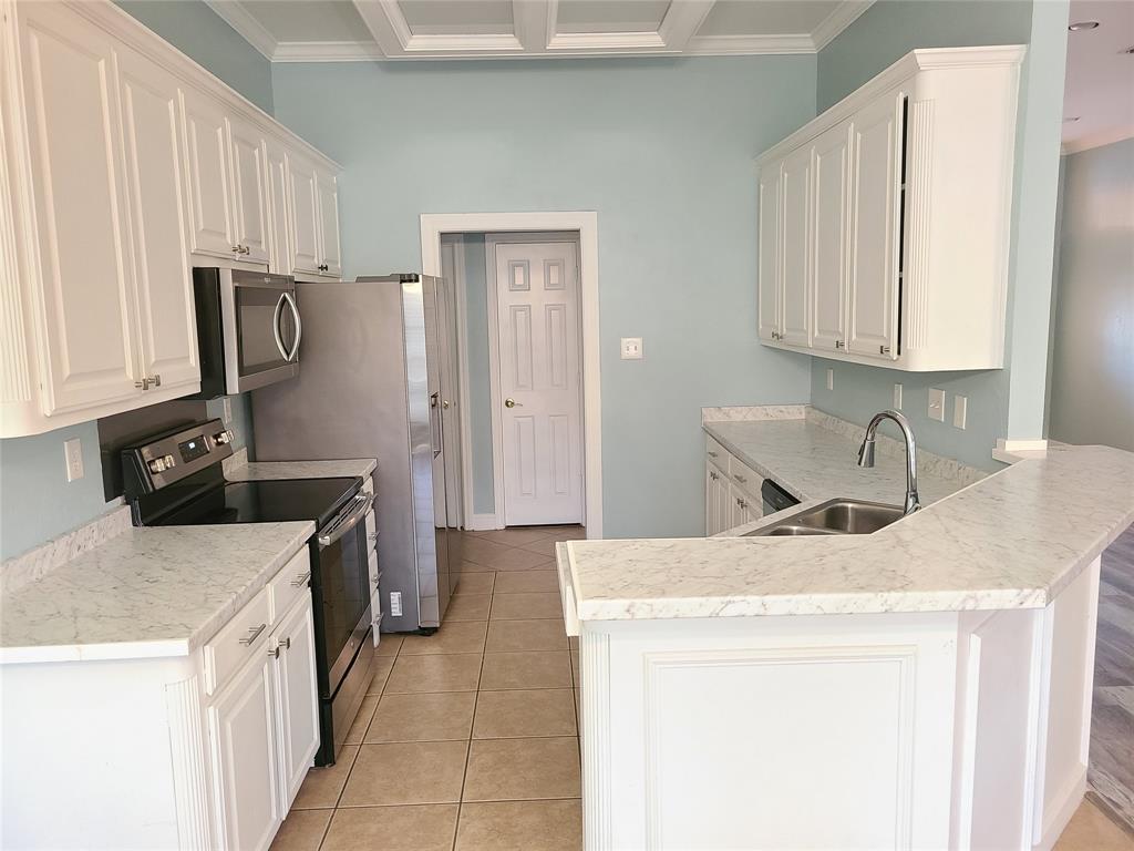 8921 Bontura Road Granbury, TX 76049 - Photo 7 of 26 a kitchen with a sink stove and cabinets