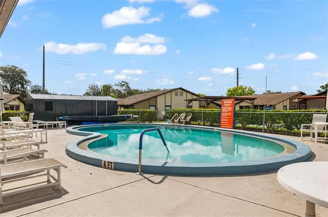 a view of a swimming pool with a patio and a yard
