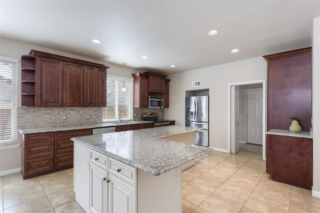 3306 Harbor Pointe Drive Rowlett, TX 75088 - Photo 14 of 40 Extensive cabinetry in two tones, granite tops, tile backsplash, ceramic floors