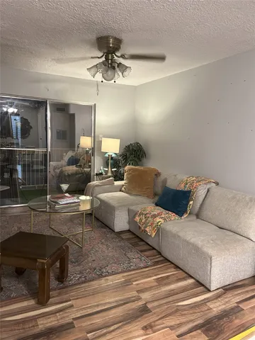 a living room with furniture and a ceiling fan
