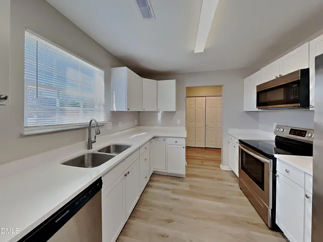 a kitchen with a sink stove and microwave