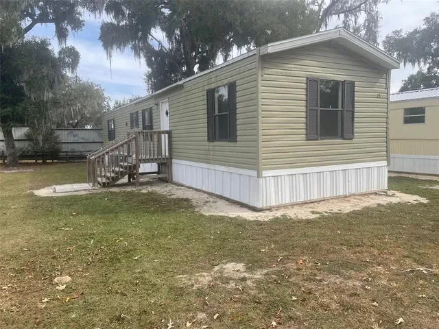 a view of a house with a yard and sitting area