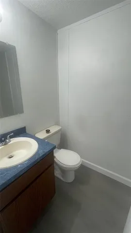 a bathroom with a granite countertop toilet and a sink