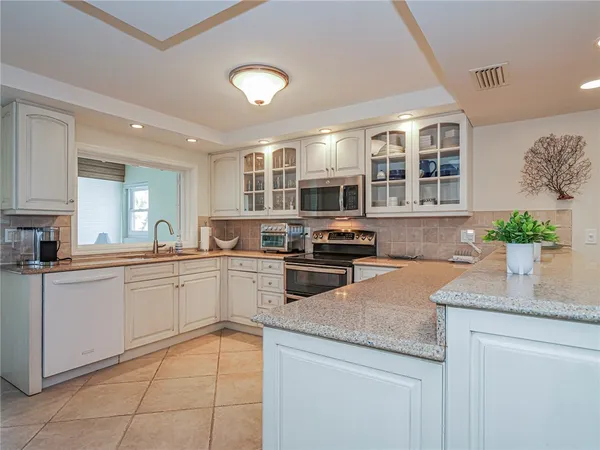 a kitchen with granite countertop a sink and cabinets