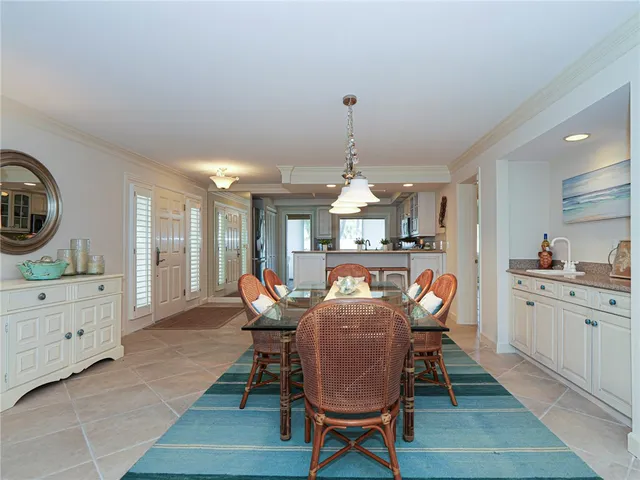 a view of a dining room and livingroom with furniture wooden floor a rug and a chandelier