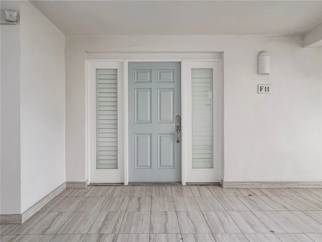 a view of an empty room with wooden floor and closet
