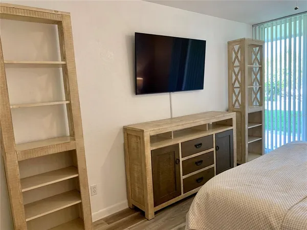 a bedroom with a bed and a flat screen tv