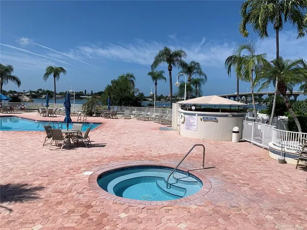 a view of a swimming pool with a patio and palm tree