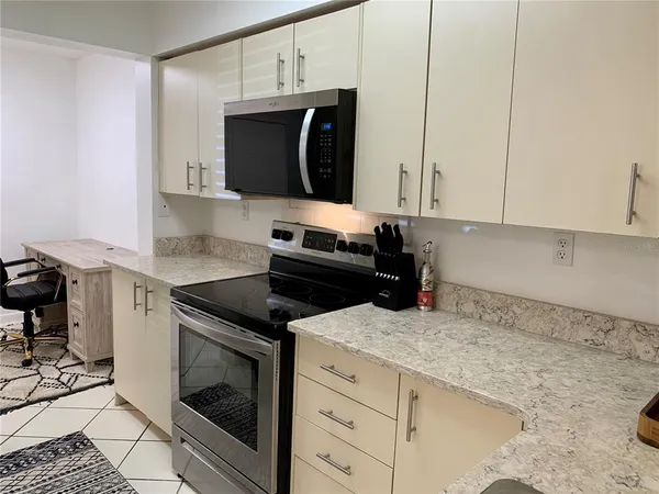 a kitchen with granite countertop a sink and a stove top oven
