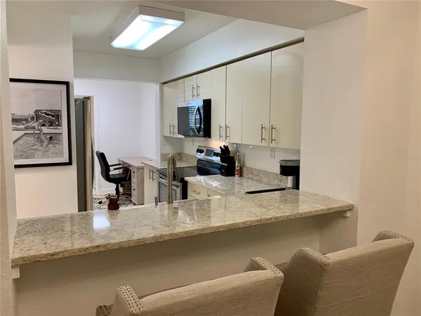 a kitchen with stainless steel appliances granite countertop a sink and a refrigerator