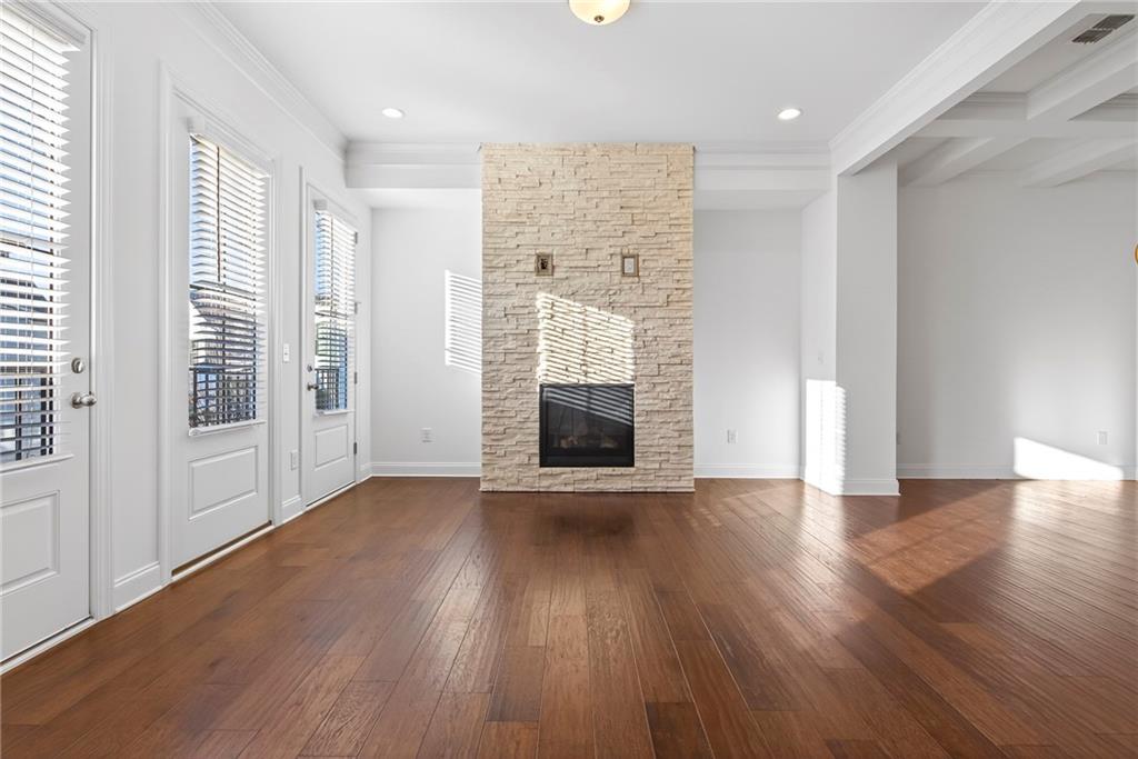 1752 Morningtide Lane Northeast Atlanta, GA 30324 - Photo 13 of 57 an empty room with wooden floor and a fireplace