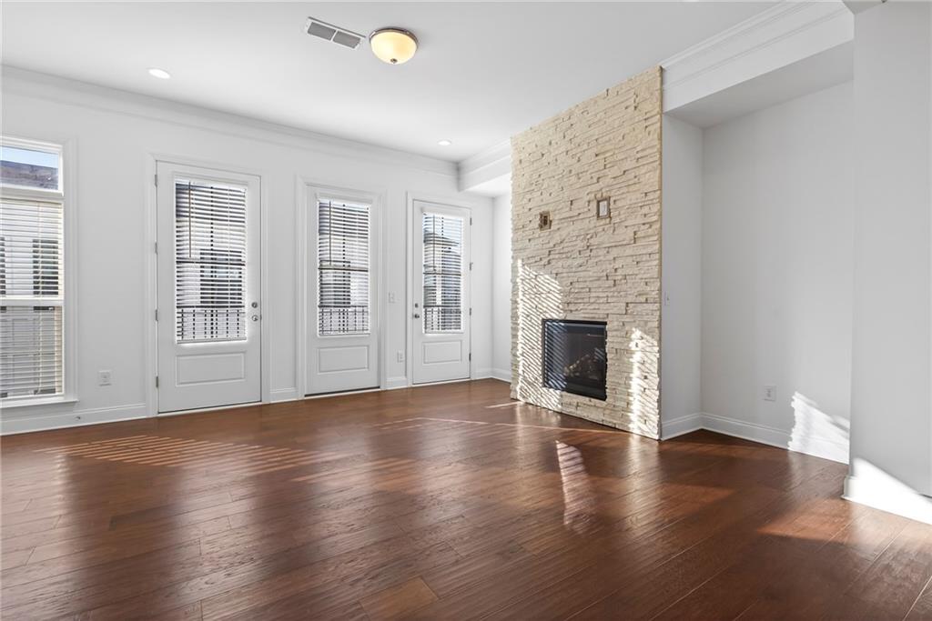 1752 Morningtide Lane Northeast Atlanta, GA 30324 - Photo 14 of 57 an empty room with wooden floor and fireplace