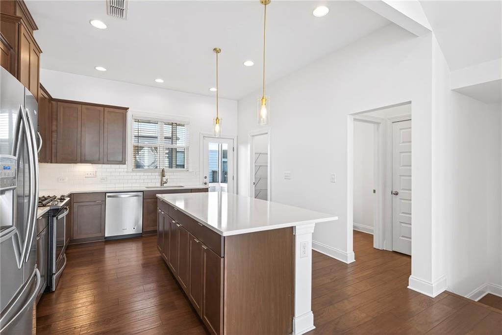 1752 Morningtide Lane Northeast Atlanta, GA 30324 - Photo 21 of 57 a large kitchen with a large counter top a sink stainless steel appliances and cabinets