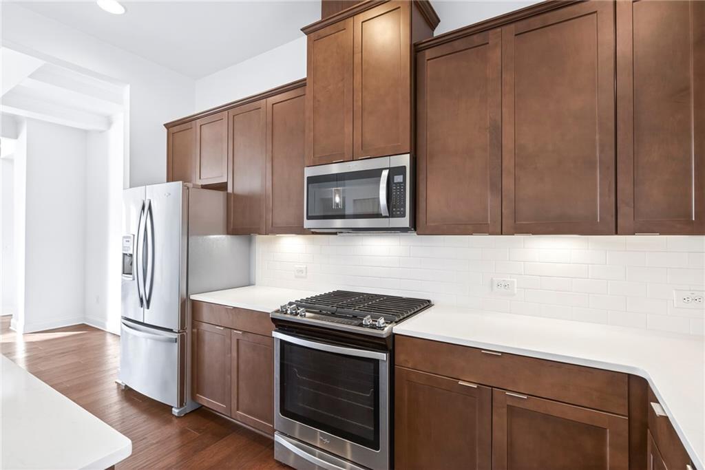 1752 Morningtide Lane Northeast Atlanta, GA 30324 - Photo 25 of 57 a kitchen with stainless steel appliances a stove a microwave and a refrigerator