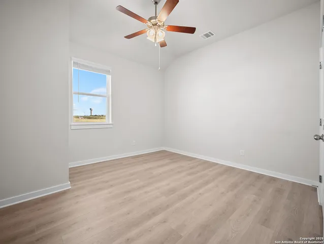 an empty room with a window and a fan