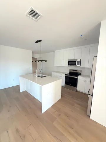 a large kitchen with stainless steel appliances and a refrigerator