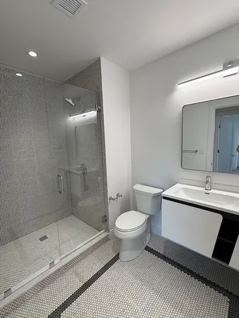 a bathroom with a sink a toilet and shower