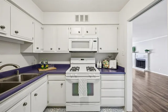 a kitchen with white cabinets and white appliances