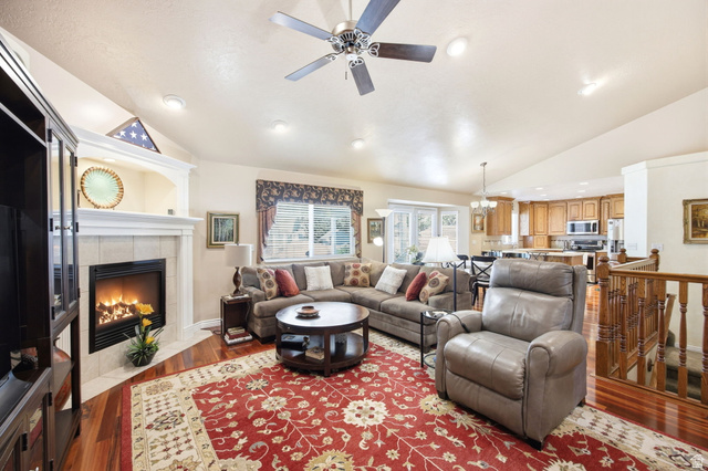 776 Flint Street Layton, UT 84041 - Photo 6 of 41 Living area featuring wood-finish flooring, a fireplace with tile surround and white mantel, and vaulted ceilings with recessed lighting