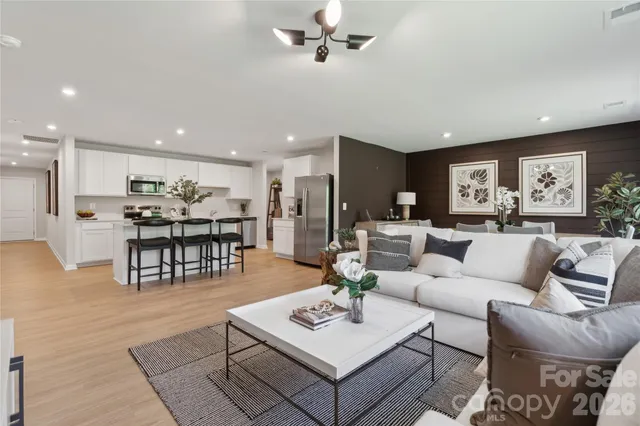 a living room with furniture and kitchen view