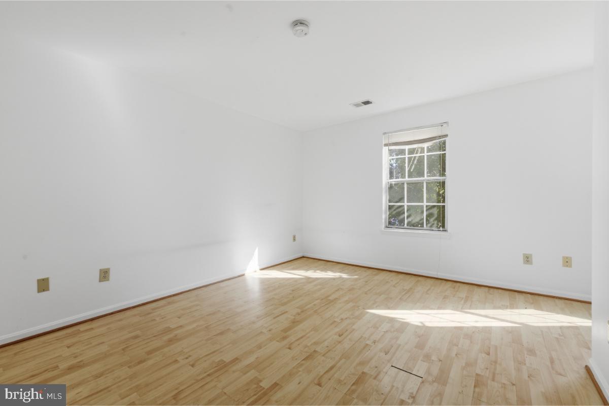 1403 Key Parkway, Unit 201 Frederick, MD 21702 - Photo 17 of 20 an empty room with wooden floor and windows