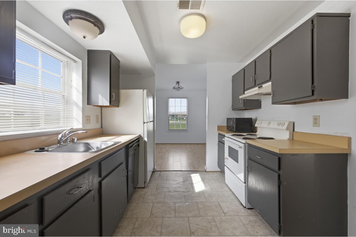1403 Key Parkway, Unit 201 Frederick, MD 21702 - Photo 10 of 20 a kitchen with stainless steel appliances granite countertop a sink stove and refrigerator