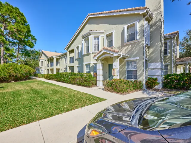 a kitchen with granite countertop a refrigerator and white cabinets