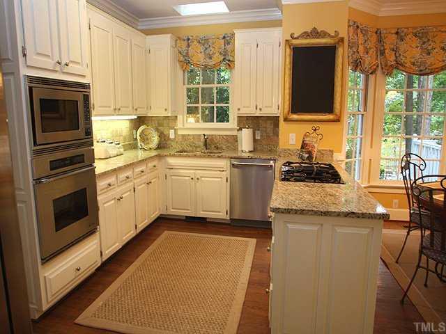 3201 Brantford Place Raleigh, NC 27607 - Photo 4 of 12 a kitchen with stainless steel appliances granite countertop a stove a sink and a microwave
