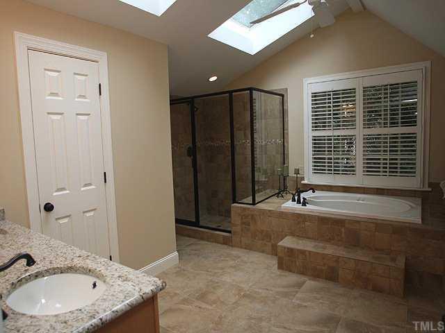 3201 Brantford Place Raleigh, NC 27607 - Photo 8 of 12 a bathroom with a granite countertop tub a sink and a large mirror