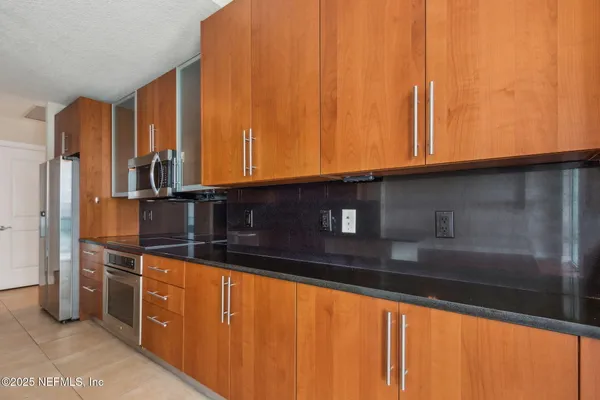 a kitchen with stainless steel appliances granite countertop a refrigerator and a stove