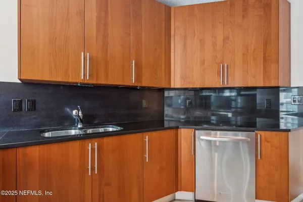 a kitchen with granite countertop cabinets and black appliances
