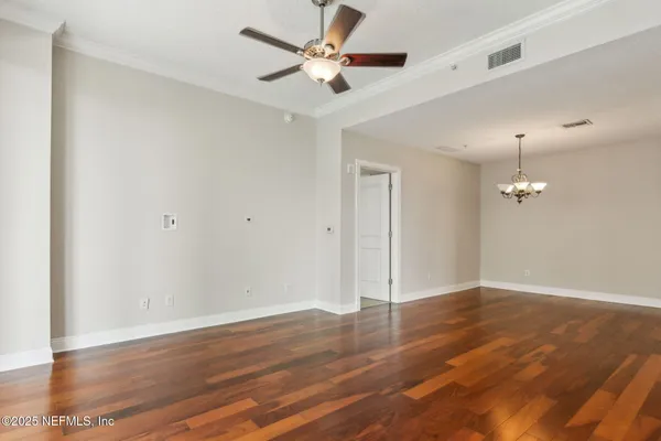 a view of an empty room with wooden floor