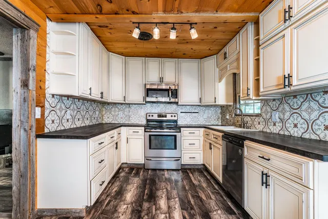 a kitchen with granite countertop a sink stove and cabinets