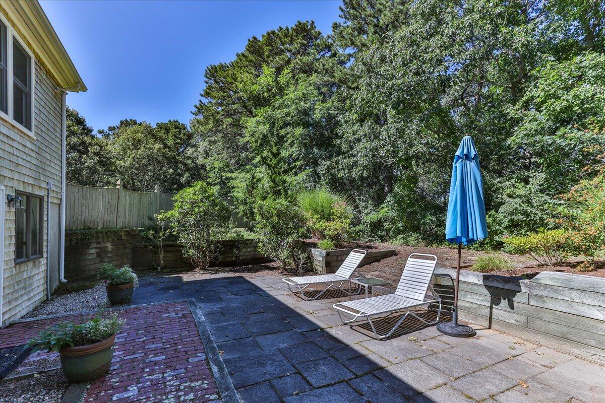 60 Pleasant Point Road Wellfleet, MA 02667 - Photo 51 of 58 a view of a patio with table and chairs potted plants with wooden fence