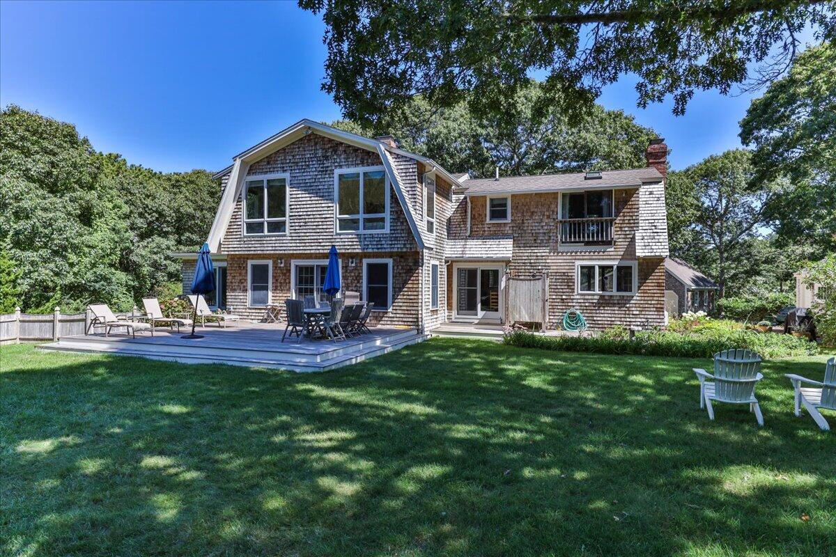60 Pleasant Point Road Wellfleet, MA 02667 - Photo 6 of 58 a front view of a house with a yard table and chairs