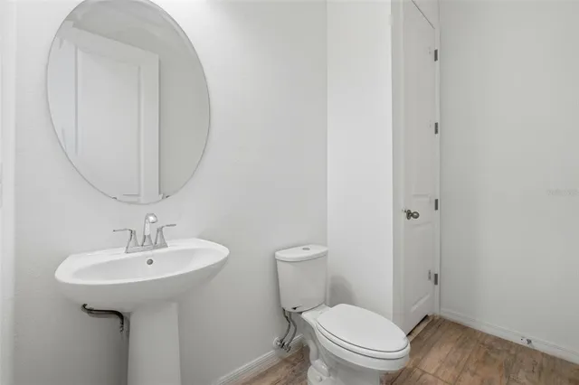 a bathroom with a toilet a sink and a mirror