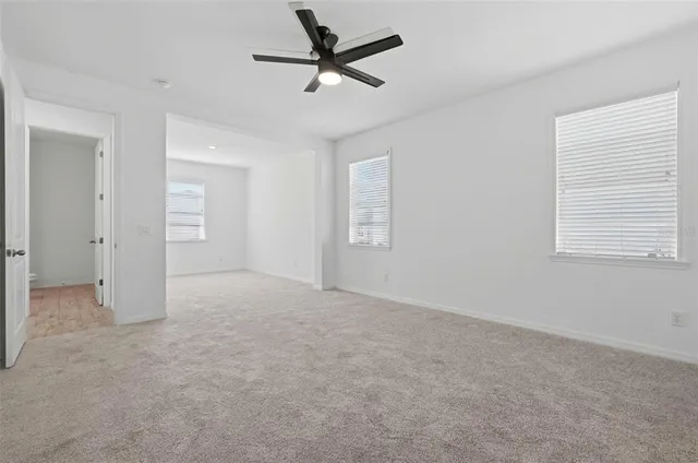 an empty room with fan and windows