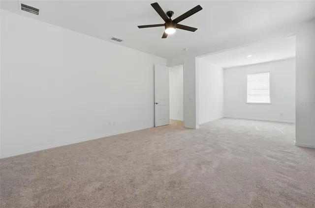 a view of a livingroom with a ceiling fan and window