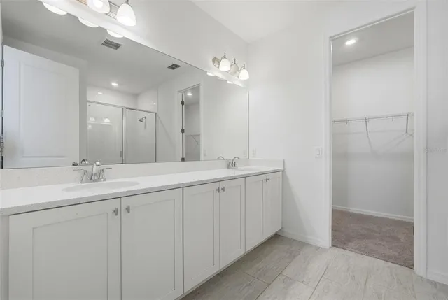 a bathroom with double sink and a mirror