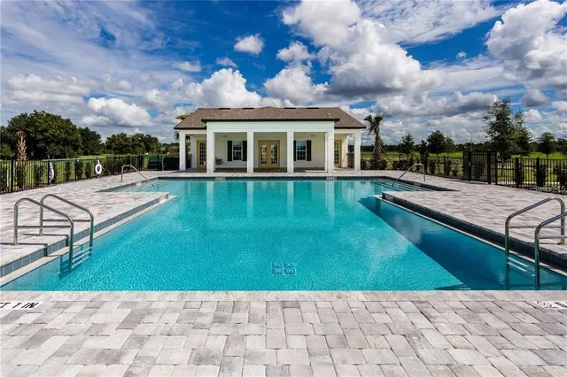 a view of house with swimming pool and sitting area