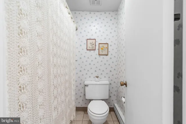 a white toilet sitting next to a white wall